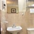 Sj Suites Hotel San Juan bathroom with sink, wall-mounted hairdryer, mirror, towel rack and toilet