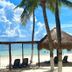 All Ritmo Cancun Resort & Water Park in Cancún, beach lounge chairs under palapa shade by the sea