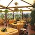 Hotel Pineta Palace Rome rooftop terrace dining area with round tables, chairs, and hanging plants