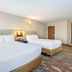 Comfort Inn Kingston - Highway 401 room with two queen beds and wall mirror in Kingston