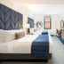 Hotel Indigo Boston Garden Boston guest room with two beds, TV, dresser and city-view window
