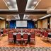 Four Points by Sheraton London ballroom with banquet tables, red chairs, and stage