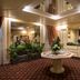 Atlante Garden Hotel Rome lobby with floral centerpiece, mirrored ceiling, and front desk