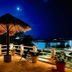 Flamingo Hotel Cozumel rooftop terrace with thatched umbrella and pool view at night
