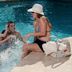 Family at poolside at Hampton Inn & Suites by Hilton San Juan, with a woman sitting by the pool in San Juan.