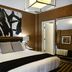 Ameritania at Times Square hotel room with king bed, abstract wall art and modern lighting in New York