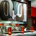 Ameritania at Times Square, New York hotel bar with white stools and abstract wall art