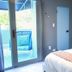 Tropica Beach Hotel San Juan guest room with sliding door to a small blue balcony seating area