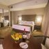 Del Pilar Miraflores Hotel Lima guest room with king bed, mirrors, desk, and fruit bowl on table