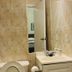 Saint Lawrence Residences and Suites Toronto bathroom with toilet, sink, mirror, and tan tiled walls