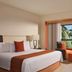 Grand Oasis Tulum in Akumal guest room with king bed, seating area, and tropical balcony view