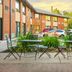 Comfort Inn Kingston - Highway 401 outdoor patio with tables, chairs, and brick hotel exterior
