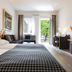 Dom Hotel Augsburg guest room with bed, desk, TV and balcony doors to greenery