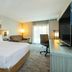 Comfort Inn Kingston - Highway 401 guest room with king bed, sofa, desk, TV and balcony door