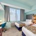 Canario Lagoon Hotel San Juan guest room with two beds, window light and desk
