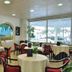 Hotel Pineta Palace in Rome dining room with round tables, red chairs, arched windows and garden view