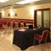 Airport Hotel Bergamo meeting room in Bagnatica with rows of red chairs and a presentation table