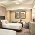 Omni Parker House Boston guest room with two beds, patterned wallpaper, framed art and dresser