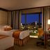 The Bostonian Boston guest room with two beds, city view, and desk overlooking Boston at night