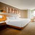 Delta Hotels by Marriott London Armouries guest room with king bed, desk, and city-view window in London