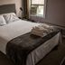Saint Lawrence Residences and Suites Toronto guest room with bed, folded towels, and window air conditioner