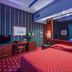 Atlante Garden Hotel Rome guest room with red bedspread, desk, TV and blue-lit drapes