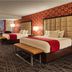 Horseshoe Las Vegas guest room with two beds, red patterned wallpaper, and city view
