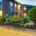 Comfort Inn Kingston - Highway 401 outdoor patio with tables, chairs and landscaping in Kingston