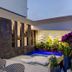Tropica Beach Hotel in San Juan courtyard with small lit pool, lounge chairs, and tropical plants