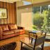 Hotel Melillanca Valdivia lounge with leather sofa, wood-paneled walls and garden-view windows