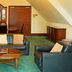 Britannia International Hotel London attic lounge with leather sofas, coffee table and green carpet