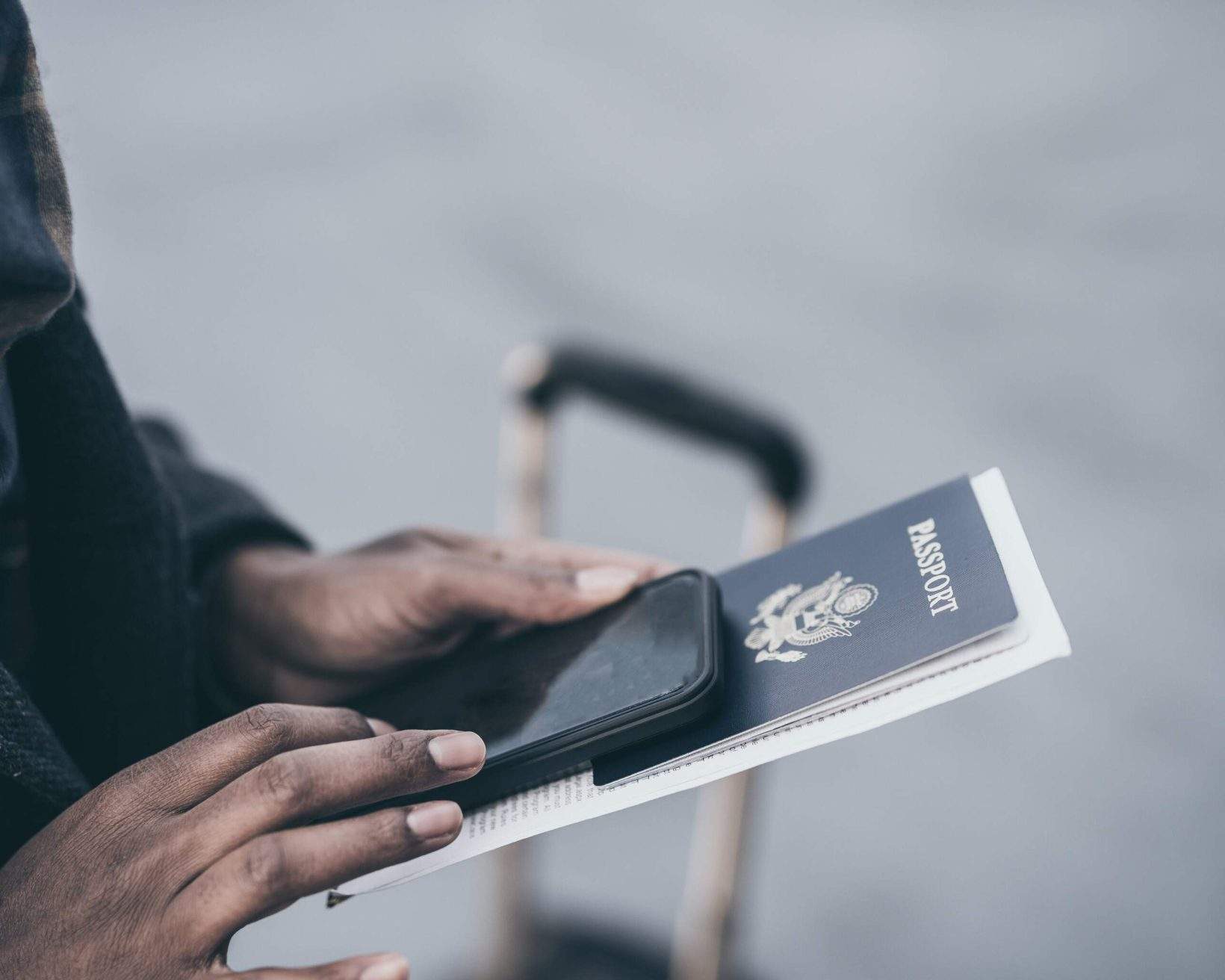 Young African American woman at airport holding passport.