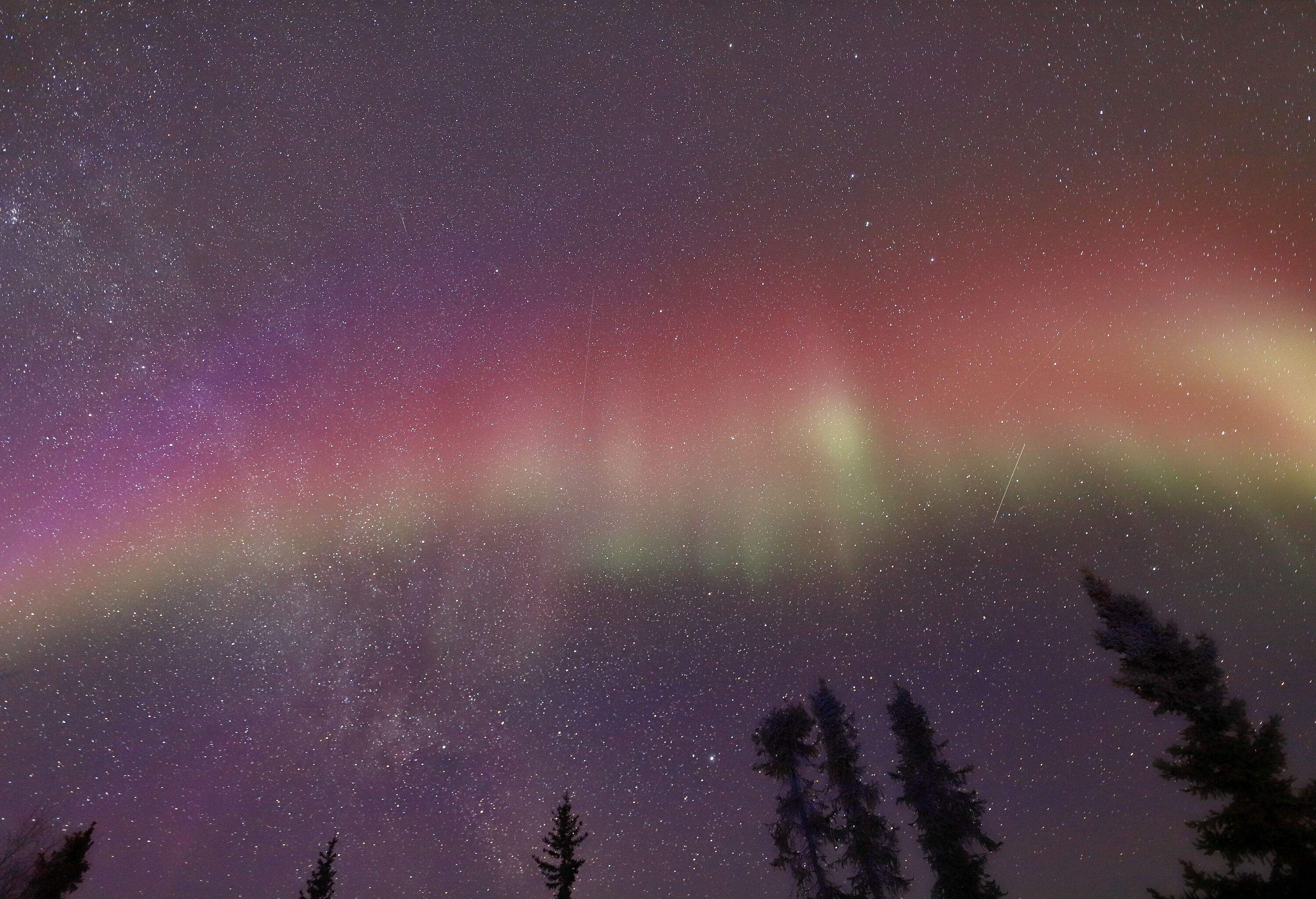 The dazzling Northern lights dance on the starry sky.