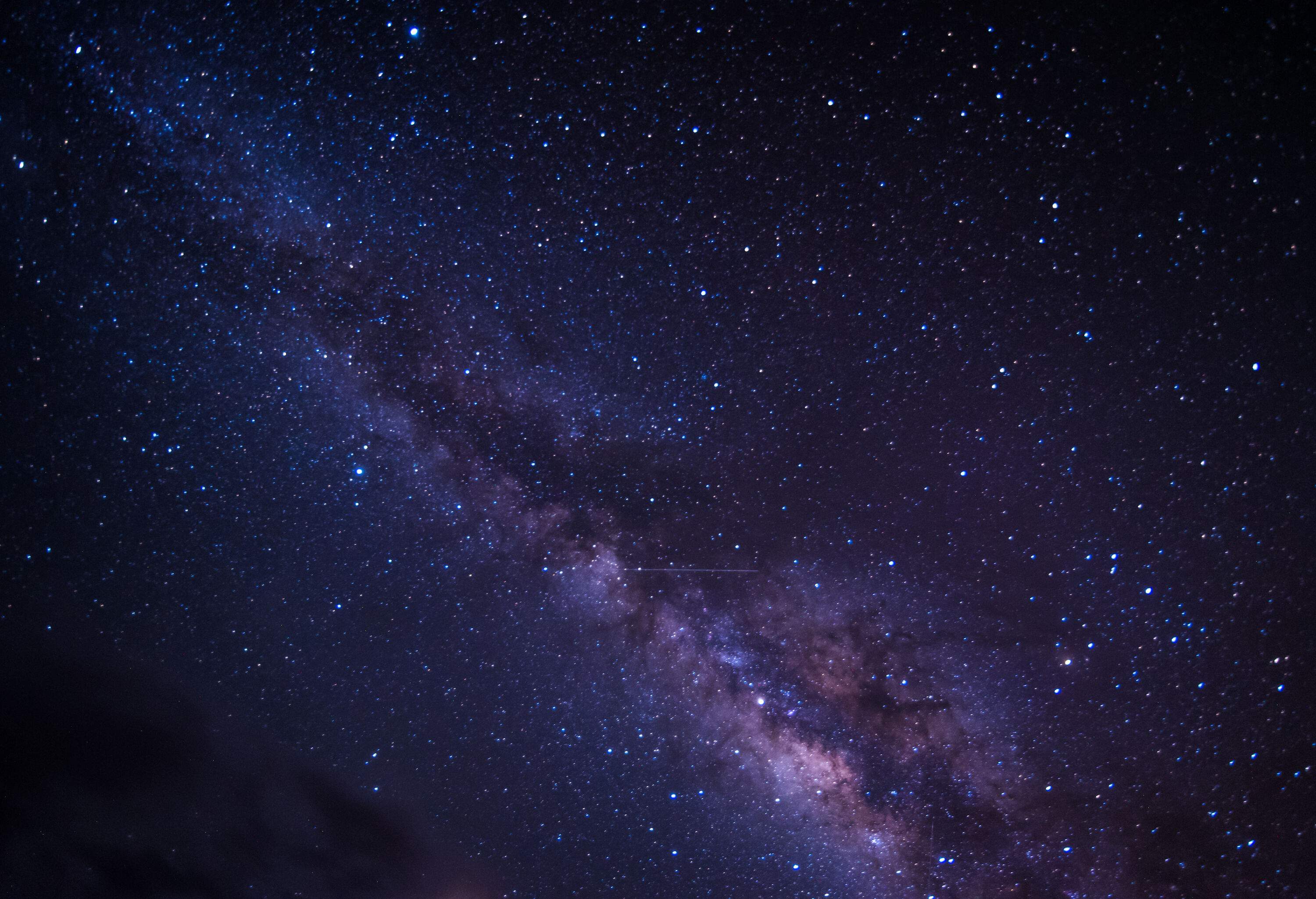 A mesmerizing image capturing the vastness of the Milky Way galaxy, adorned with a multitude of colourful stars and ethereal space dust.